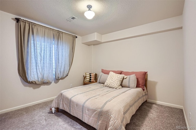 bedroom featuring a textured ceiling and carpet floors