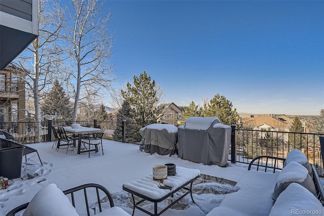 snow covered patio featuring a grill