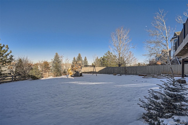 yard layered in snow with a playground