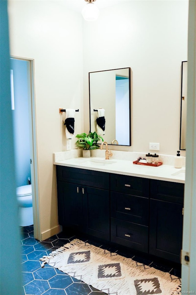 bathroom featuring tile patterned flooring, vanity, and toilet