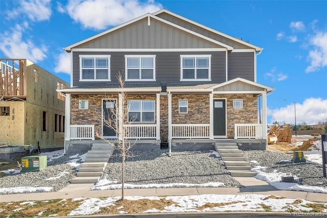 view of front of house featuring stairs, a porch, and stone siding