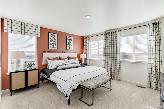 bedroom with visible vents, baseboards, and light carpet