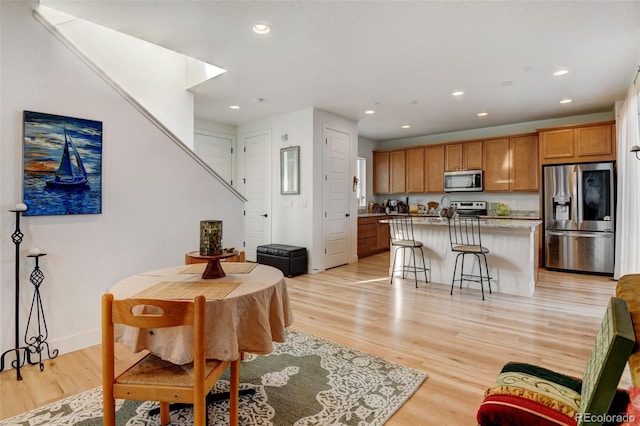 dining space with baseboards, recessed lighting, and light wood-style floors