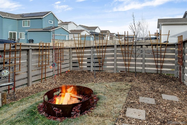 view of yard with an outdoor fire pit, a residential view, and a fenced backyard