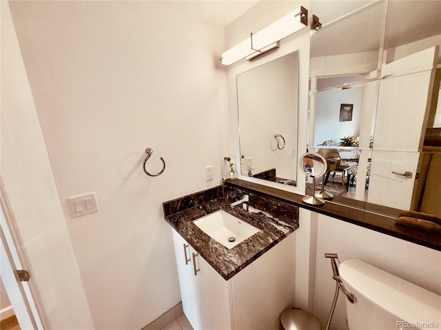 bathroom with tile flooring, vanity, and toilet