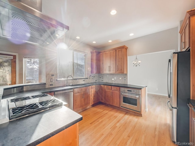 kitchen with sink, decorative backsplash, light hardwood / wood-style flooring, and stainless steel appliances