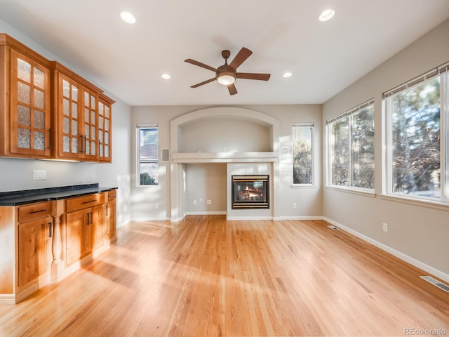 unfurnished living room featuring ceiling fan and light hardwood / wood-style flooring