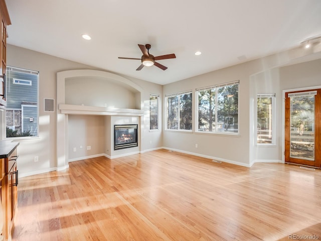 unfurnished living room featuring ceiling fan and light hardwood / wood-style floors