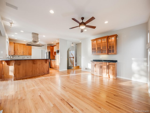 unfurnished living room featuring ceiling fan, sink, and light hardwood / wood-style floors