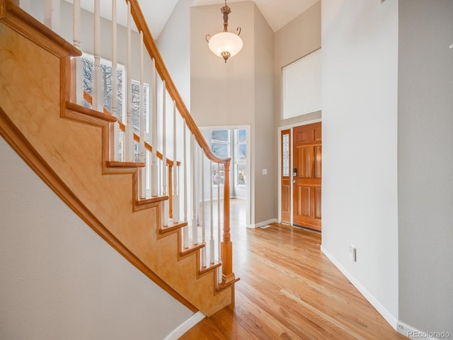 foyer with a towering ceiling and light hardwood / wood-style flooring