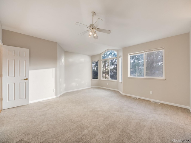 carpeted spare room with ceiling fan and lofted ceiling