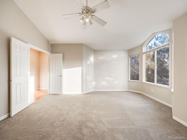 spare room featuring ceiling fan, carpet flooring, and vaulted ceiling