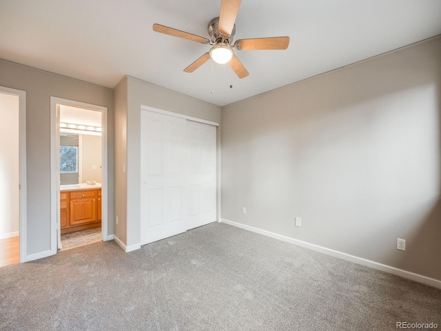 unfurnished bedroom featuring ceiling fan, ensuite bathroom, carpet flooring, and a closet