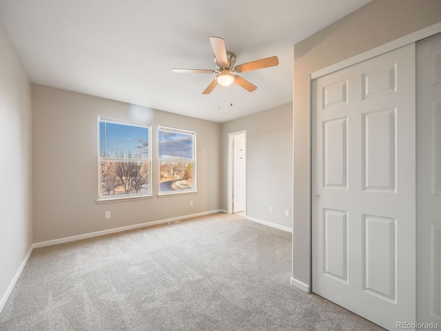 empty room featuring light colored carpet and ceiling fan