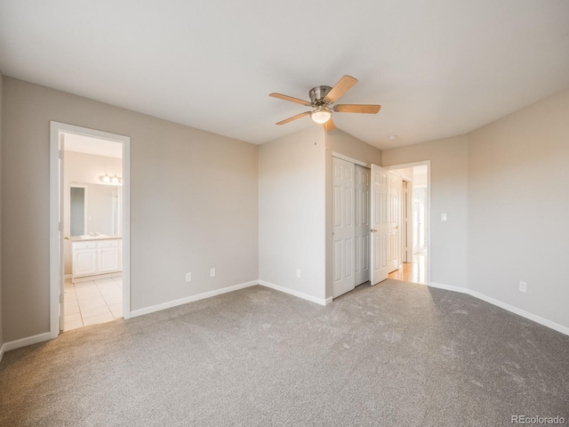 unfurnished bedroom with ceiling fan, light colored carpet, and ensuite bath