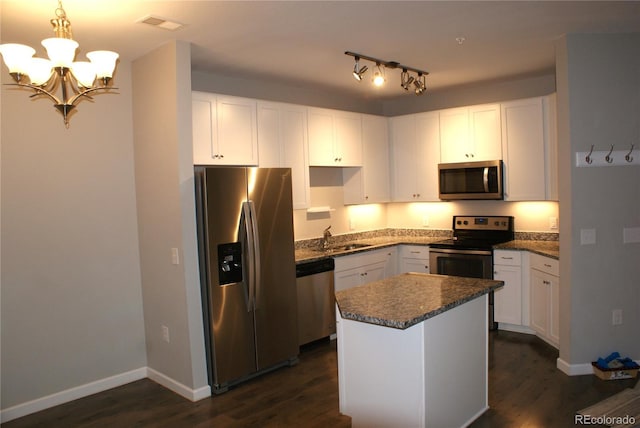 kitchen featuring appliances with stainless steel finishes, white cabinetry, a kitchen island, and pendant lighting