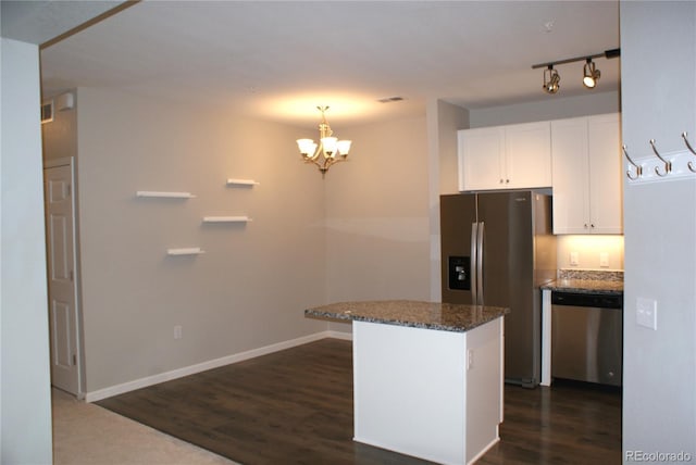 kitchen featuring dark hardwood / wood-style flooring, dark stone counters, stainless steel appliances, a notable chandelier, and white cabinets