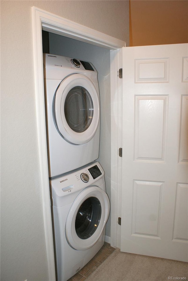 washroom featuring light tile patterned floors and stacked washer / drying machine