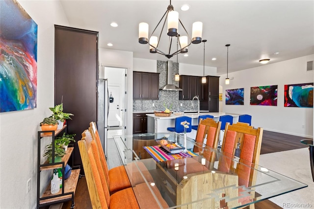 dining room with hardwood / wood-style floors, an inviting chandelier, and sink