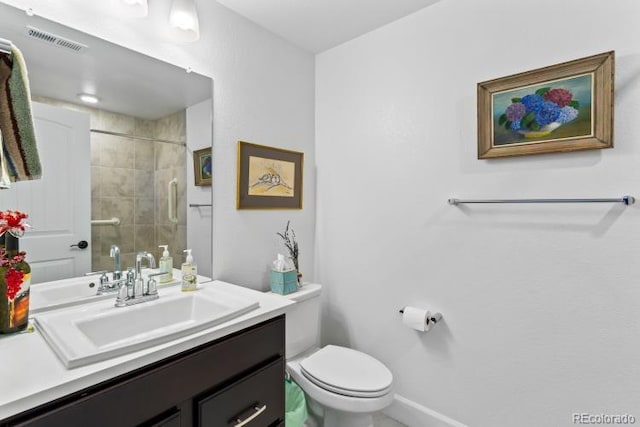 bathroom featuring vanity, toilet, and a tile shower