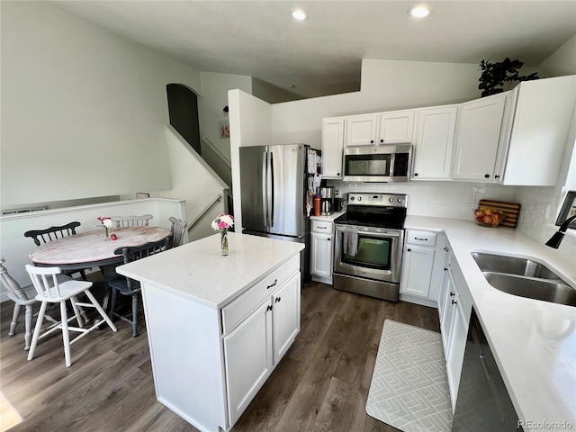 4178 E 94th Pl, Thornton, CO 80229 - kitchen featuring appliances with stainless steel finishes, a sink, vaulted ceiling, decorative backsplash, and white cabinets