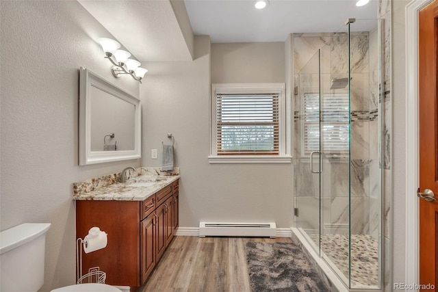 full bath featuring a baseboard radiator, a shower stall, wood finished floors, vanity, and recessed lighting