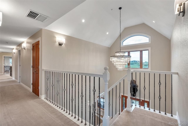 hallway with a chandelier, carpet flooring, vaulted ceiling, an upstairs landing, and baseboards