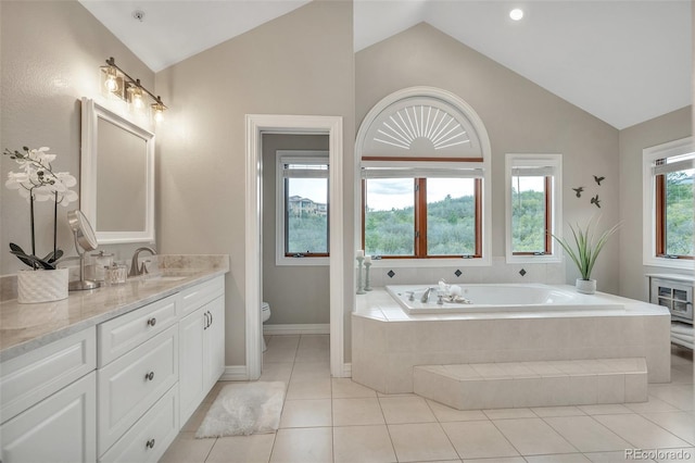 full bathroom with vaulted ceiling, a garden tub, toilet, tile patterned floors, and vanity
