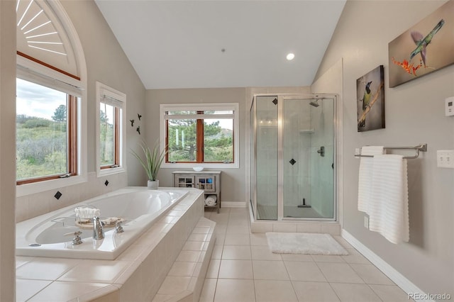 bathroom featuring lofted ceiling, a shower stall, baseboards, a bath, and tile patterned flooring