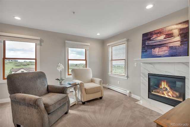 living area featuring a baseboard heating unit, light carpet, a tile fireplace, baseboards, and recessed lighting