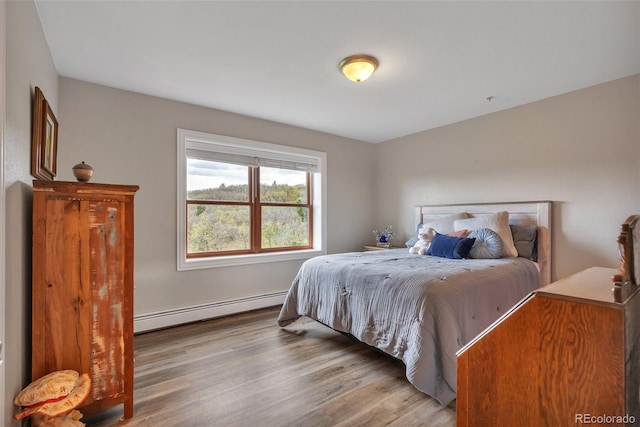 bedroom featuring baseboard heating and wood finished floors