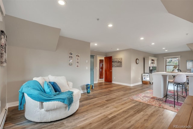 living area featuring baseboards, light wood-style flooring, recessed lighting, a baseboard heating unit, and an office area