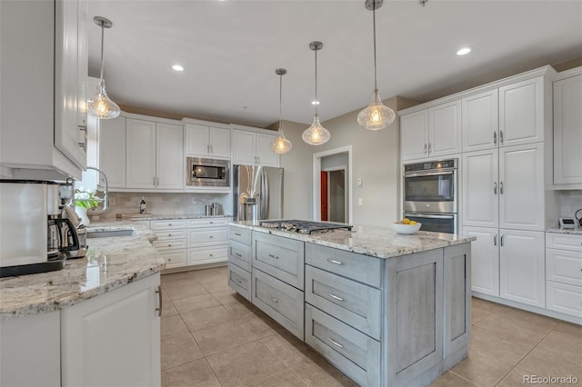 kitchen featuring appliances with stainless steel finishes, decorative backsplash, a center island, white cabinets, and recessed lighting
