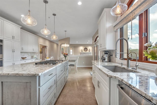 kitchen with stainless steel appliances, a sink, healthy amount of natural light, recessed lighting, and white cabinetry