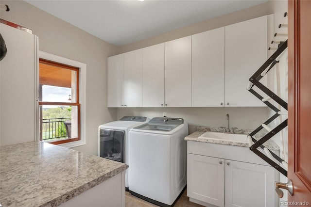 clothes washing area featuring cabinet space and separate washer and dryer