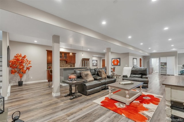 living room with light wood-style flooring, recessed lighting, stairs, and baseboards