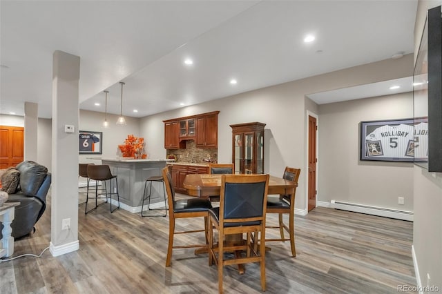 dining area with a baseboard heating unit, light wood-type flooring, baseboards, and recessed lighting