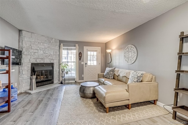 1068 Milo Cir Unit A, Lafayette, CO 80026 - living room featuring wood finished floors, a textured ceiling, and a stone fireplace