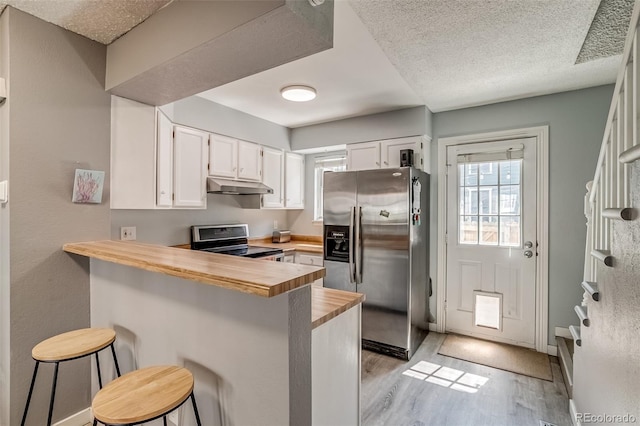 1068 Milo Cir Unit A, Lafayette, CO 80026 - kitchen with stainless steel fridge, electric range oven, under cabinet range hood, light wood-style floors, and a peninsula