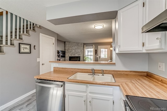 1068 Milo Cir Unit A, Lafayette, CO 80026 - kitchen with stainless steel dishwasher, extractor fan, a textured ceiling, white cabinetry, and wooden counters