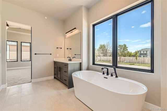 bathroom with a bathing tub, tile patterned flooring, and vanity