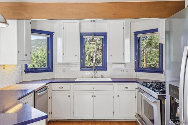 5939 S Skyline Dr, Evergreen, CO 80439 - kitchen with stainless steel appliances, white cabinets, and dark countertops