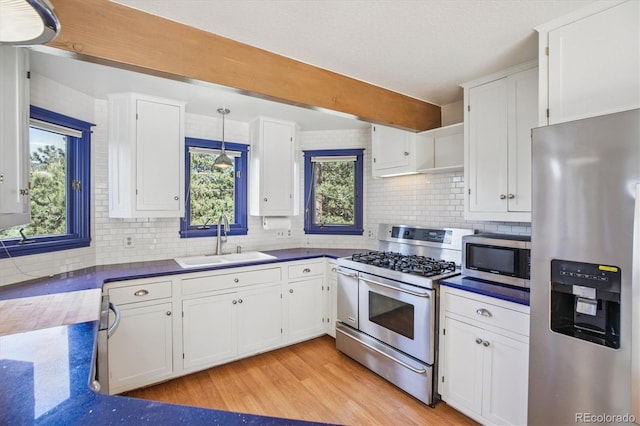 5939 S Skyline Dr, Evergreen, CO 80439 - kitchen with appliances with stainless steel finishes, white cabinetry, tasteful backsplash, light wood-style flooring, and beam ceiling
