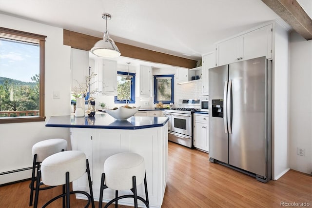 5939 S Skyline Dr, Evergreen, CO 80439 - kitchen featuring appliances with stainless steel finishes, dark countertops, a peninsula, light wood-style flooring, and white cabinets