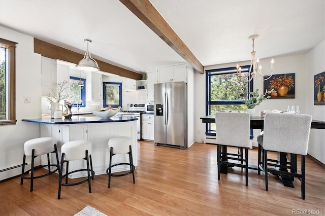 5939 S Skyline Dr, Evergreen, CO 80439 - kitchen featuring appliances with stainless steel finishes, dark countertops, a peninsula, white cabinetry, and beamed ceiling