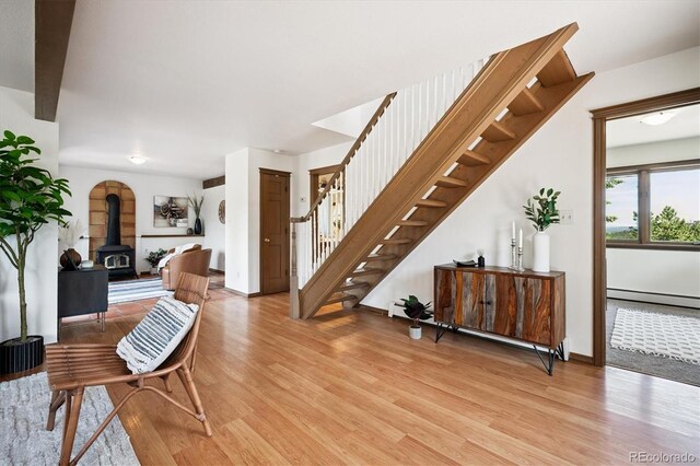 5939 S Skyline Dr, Evergreen, CO 80439 - foyer entrance featuring stairway, light wood-style flooring, baseboard heating, and a wood stove