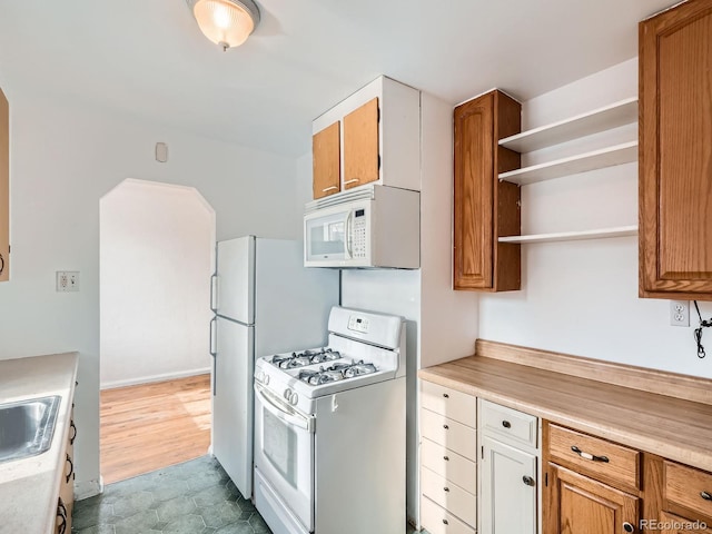 kitchen featuring white appliances and sink