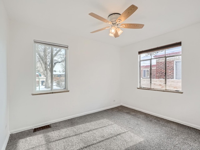 carpeted spare room featuring ceiling fan