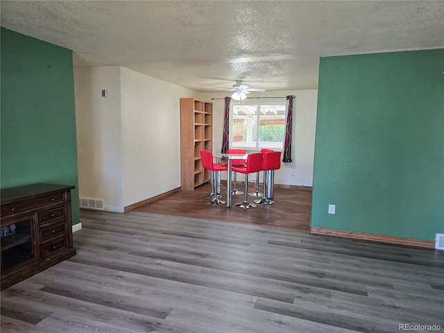 dining space featuring a textured ceiling, ceiling fan, and hardwood / wood-style flooring