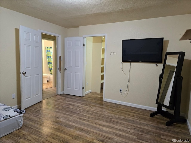 bedroom featuring a textured ceiling and dark hardwood / wood-style floors